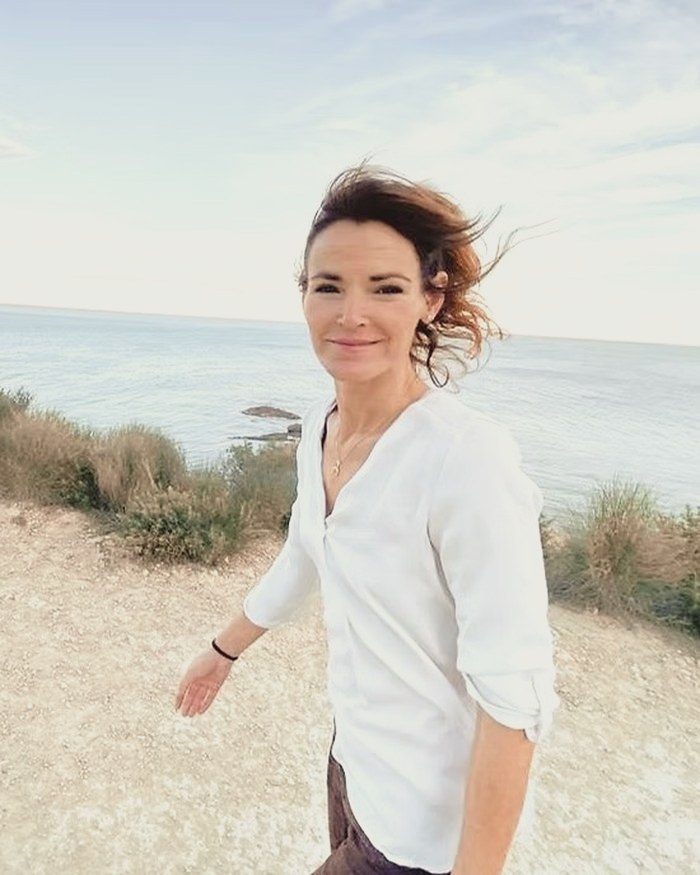 Retrato de Araceli Lozano al aire libre, con el pelo al viento frente al mar