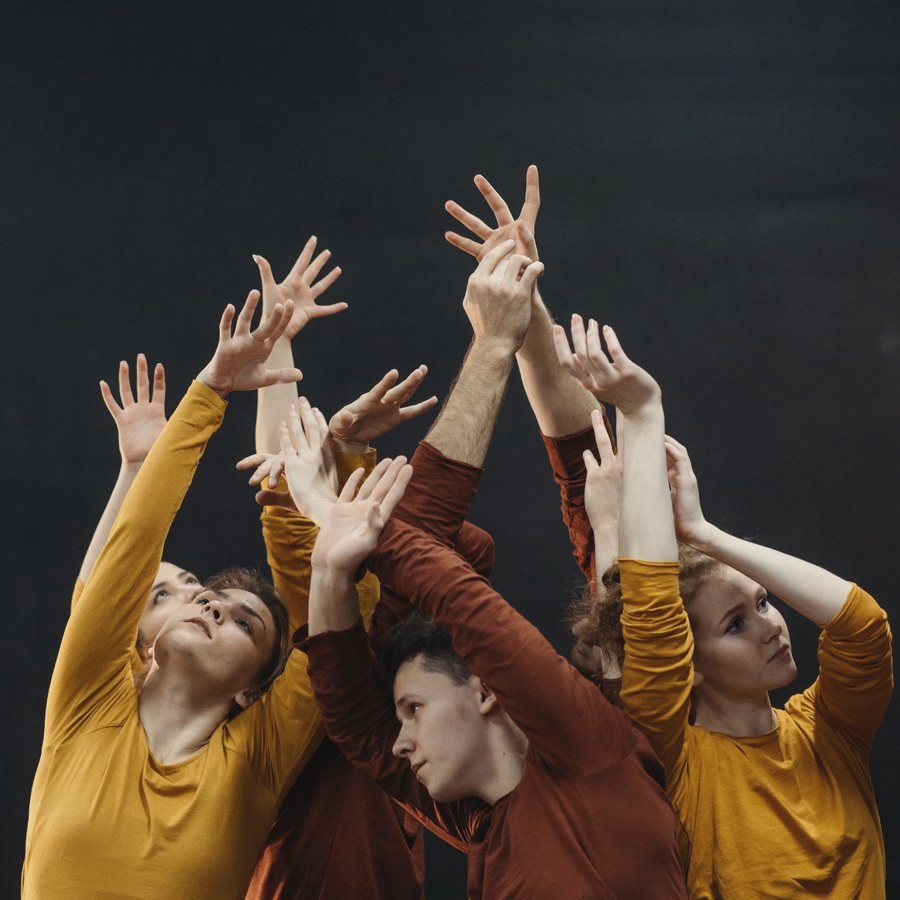 Grupo de bailarines con los brazos alzados en un ejercicio de improvisación de Lab Movimiento Creativo